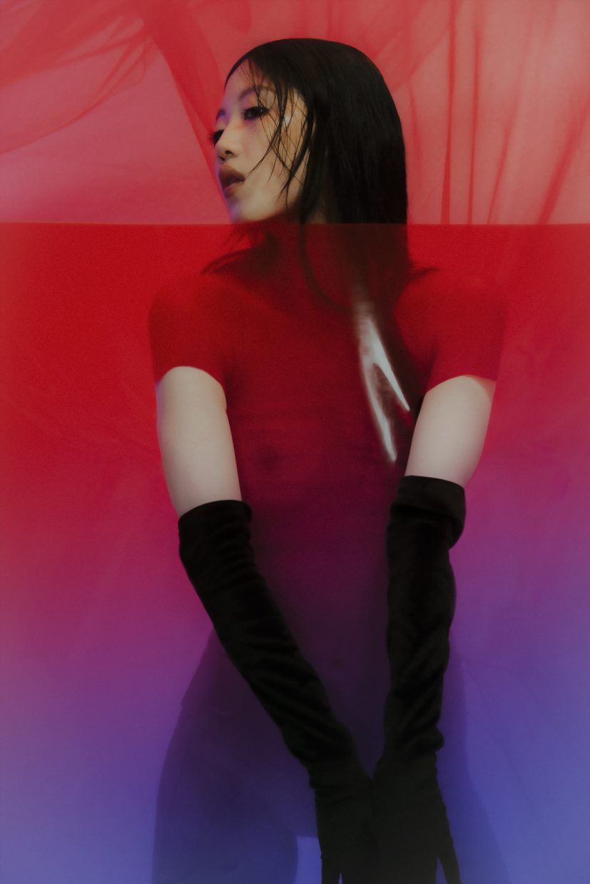 Model Loo Loo shot by Olga Urbanek wears long black gloves on a red to purple background