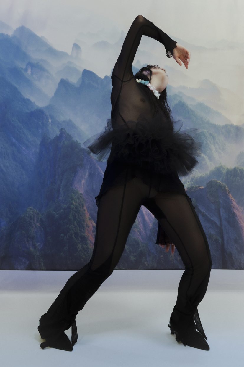 Model Loo Loo, fotografiert von Olga Urbanek vor einem bergigen Hintergrund, scheint zu fallen